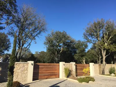 a wooden fence in front of some trees at Sweet Holiday in Porto-Vecchio