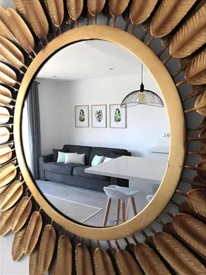 a mirror in a living room with a couch and a table at Sweet Holiday in Porto-Vecchio