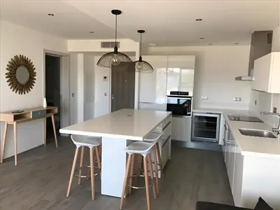 a kitchen with a white counter and stools in it at Sweet Holiday in Porto-Vecchio