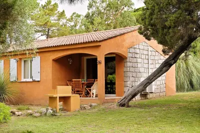 a small orange house with a table and chairs at Villas Abbartello in Olmeto