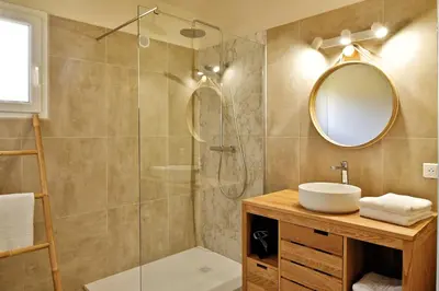 a bathroom with a shower and a sink and a mirror at Villas Abbartello in Olmeto