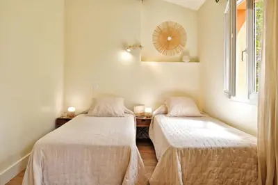 two beds in a room with a table and a mirror at Villas Abbartello in Olmeto