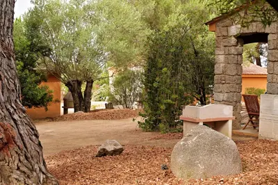 a stone bench and a rock in a yard at Villas Abbartello in Olmeto