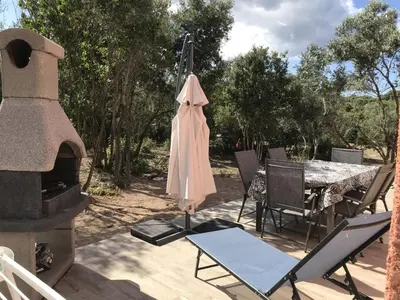 a patio with a fireplace and a table and chairs at Mini-villas Célia à BONIFACIO in Bonifacio