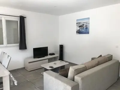 a living room with a couch and a tv at Mini-villas Célia à BONIFACIO in Bonifacio