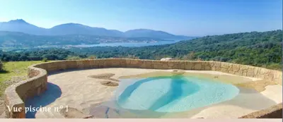 a large swimming pool with a view of the mountains at BERGERIE PARADISU, Domaine de l Ogliastru in Olmeto