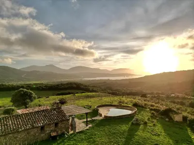 a view of a field with a building and a bridge at BERGERIE PARADISU, Domaine de l Ogliastru in Olmeto