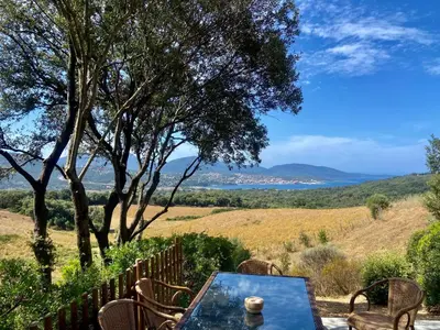 a table and chairs with a view of a field at BERGERIE A Murta, Domaine de l Ogliastru in Olmeto