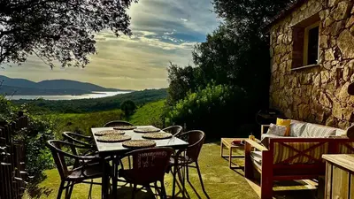 a table and chairs on a patio with a view at BERGERIE A Murta, Domaine de l Ogliastru in Olmeto