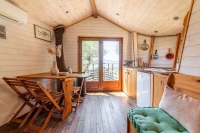 a kitchen with a table and chairs in a cabin at Cabane Dans les Arbres, Domaine de l Ogliastru in Olmeto