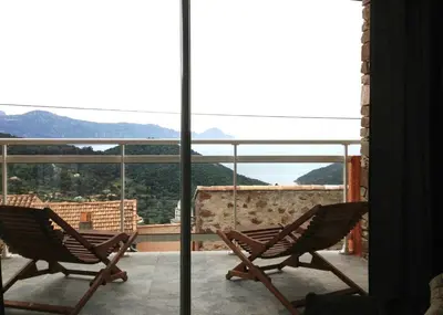two chairs on a balcony with a view of the mountains at Casa Suprana in Partinello