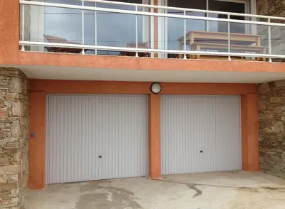 two garage doors on a building with a balcony at Casa Suprana in Partinello
