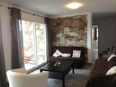 a living room with a couch and a stone wall at Casa Suprana in Partinello