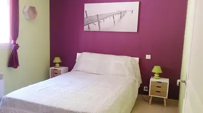 a bedroom with a white bed and a purple wall at Villa Les hauts de Benista in Porticcio