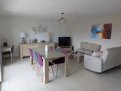 a living room with a table and a couch at Les Terrasses De Vignola in Porto-Vecchio
