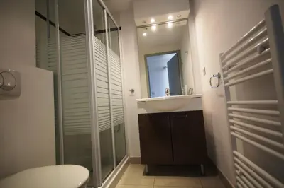a bathroom with a sink and a glass shower at Les Terrasses De Vignola in Porto-Vecchio