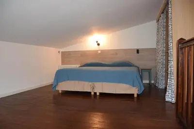 a bedroom with a bed with a blue blanket at Résidence Casa Cintrone in Porto Pollo