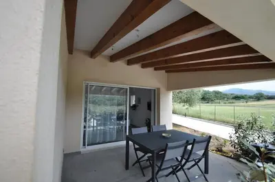 a patio with a black table and chairs and a window at Résidence Casa Cintrone in Porto Pollo