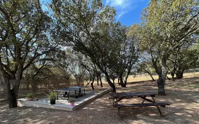 a table and chairs on a porch with a view of a field at Résidence Casa Cintrone in Porto Pollo
