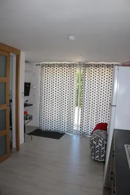 a living room with a sliding door with curtains at Claude et Marie-France in Alata