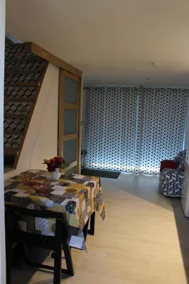 a living room with a table and a room with a staircase at Claude et Marie-France in Alata