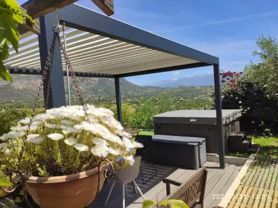 a patio with a gazebo with flowers and a grill at Claude et Marie-France in Alata