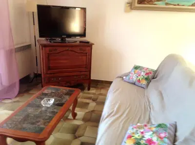 a living room with a couch and a table and a tv at Beau F4 petreto-Bicchisano in Petreto-Bicchisano