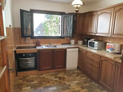 a kitchen with wooden cabinets and a sink and a window at Beau F4 petreto-Bicchisano in Petreto-Bicchisano