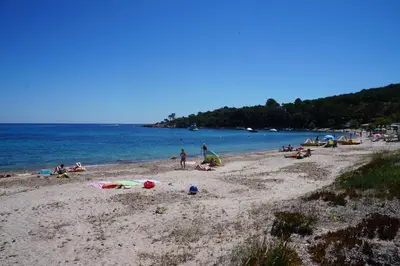 a group of people on a beach near the water at Vue mer Corse in Conca