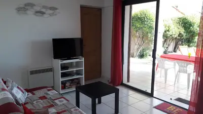 a living room with a couch and a tv and a table at Vue mer Corse in Conca