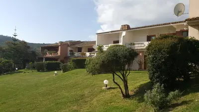 a house with a green yard in front of it at Vue mer Corse in Conca