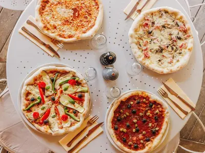 a table with three pizzas on top of it at Vigna Maggiore in Olmeto