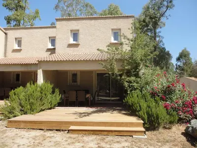 a house with a wooden deck in front of it at BAGHEERA Village Naturiste in Linguizzetta