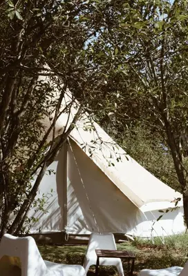 a white tent sitting under a bunch of trees at Village Del Mar in Solaro