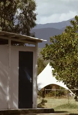 a white building with a black door and a tent at Village Del Mar in Solaro