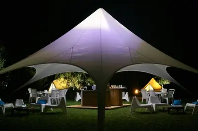 a group of chairs under a white umbrella at night at Village Del Mar in Solaro