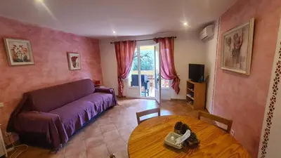 a living room with a couch and a table at Locations Résidence Rocca Rossa Palombaggia classées 3 étoiles in Porto-Vecchio