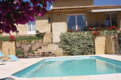 a swimming pool in front of a house at Locations Résidence Rocca Rossa Palombaggia classées 3 étoiles in Porto-Vecchio