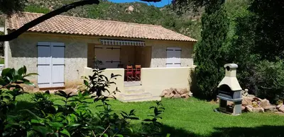 a small house with white doors and a yard at Locations Résidence Rocca Rossa Palombaggia classées 3 étoiles in Porto-Vecchio