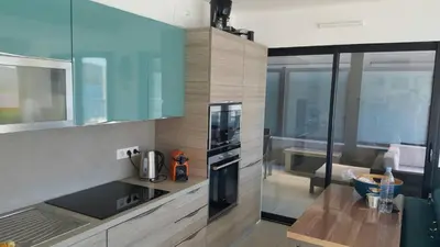 a kitchen with blue cabinets and a stove top oven at Plage Propriano 4 étoiles in Propriano