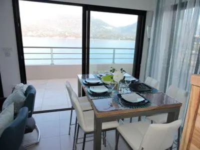 a dining room table with chairs and a view of the ocean at Plage Propriano 4 étoiles in Propriano