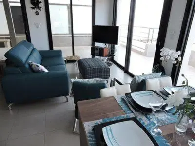 a living room with a blue couch and a table at Plage Propriano 4 étoiles in Propriano
