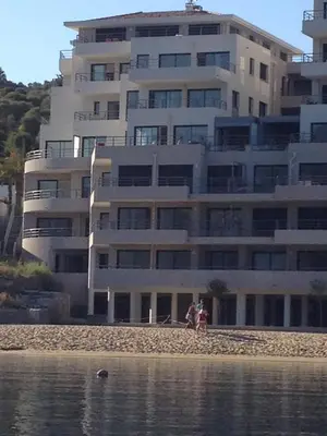 a large building on the beach next to the water at Plage Propriano 4 étoiles in Propriano