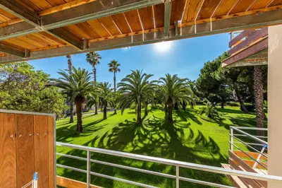 a view from the balcony of a house with palm trees at Hotel Club Marina Viva in Porticcio