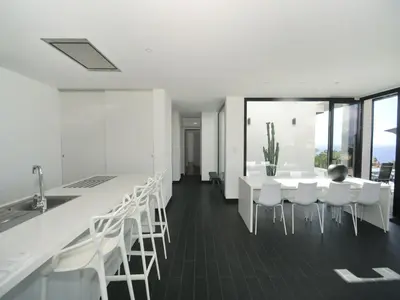a kitchen with white chairs and a table and a counter at Sunset Villa with Bay View in Molini