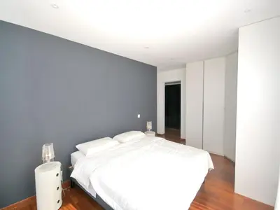 a bedroom with a white bed and a wall at Sunset Villa with Bay View in Molini