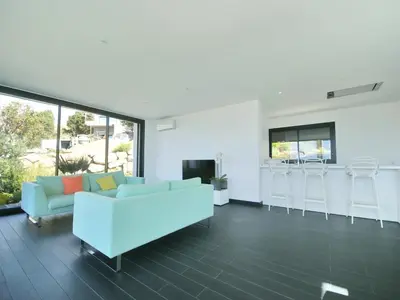 a living room with a white couch and a kitchen at Sunset Villa with Bay View in Molini