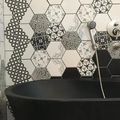a bathroom with a black tub and a tile wall at Lodge de Charme A Cheda in Bonifacio
