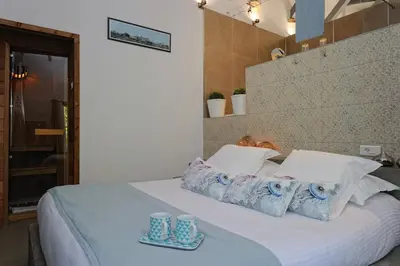a bed with blue and white pillows and cups on it at Lodge de Charme A Cheda in Bonifacio