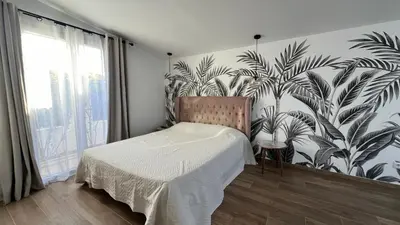 a bedroom with a bed with a mural of palm trees at Villa Altea- Lido Marana - piscine privée exclusive - plage à pied - 3 bedrooms house - private swimming pool - beach access on foot in Bastia